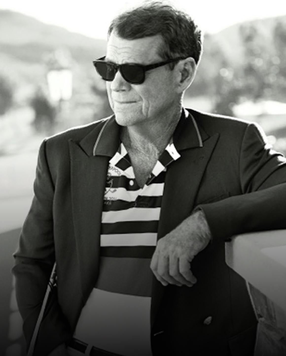 Black-and-white photo of Tom Watson in blazer and striped Polo shirt.