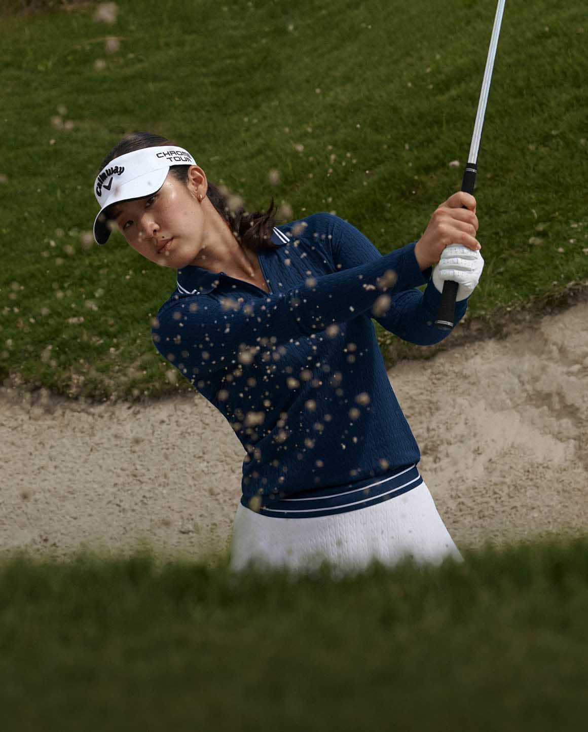 Andrea Lee on golf course wears light green Polo and pleated skirt.